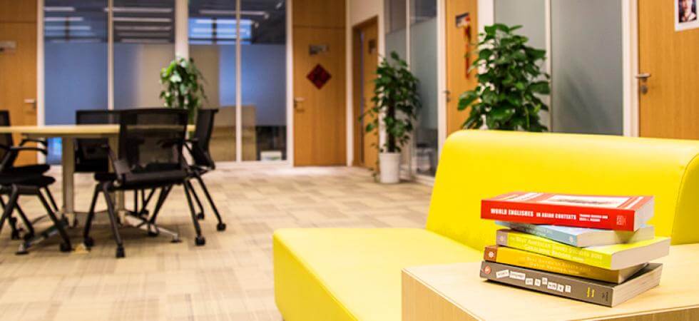 Study space with yellow couch, table and chairs, and several books Study space with yellow couch, table and chairs, and several books